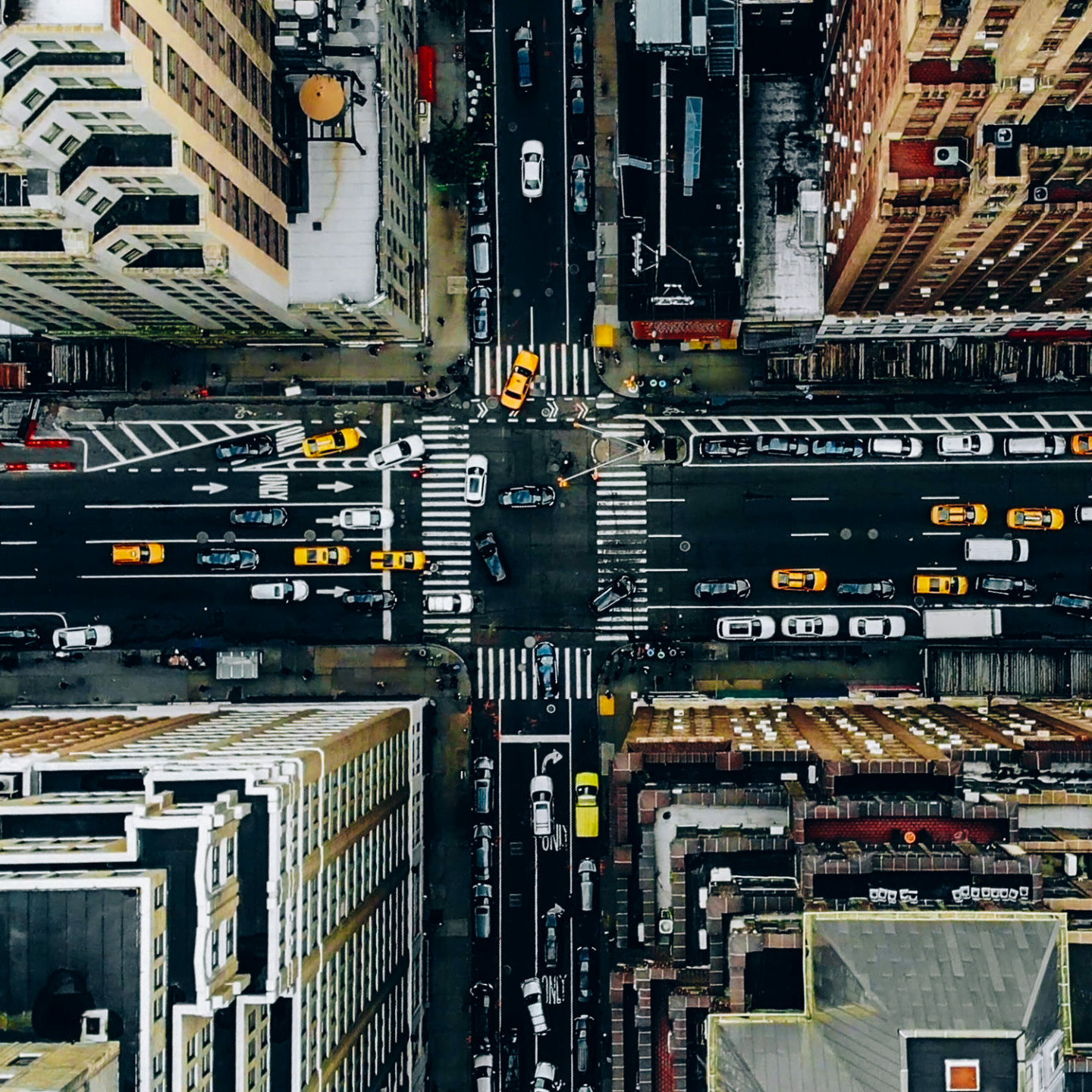 Aerial view of New York downtown building roofs. Bird's eye view from helicopter of cityscape metropolis infrastructure, traffic cars, yellow cabs moving on city streets and crossing district avenues