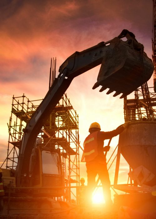 Silhouette Teams of Business Engineers looking for blueprints in construction sites through blurry construction sites at sunset.